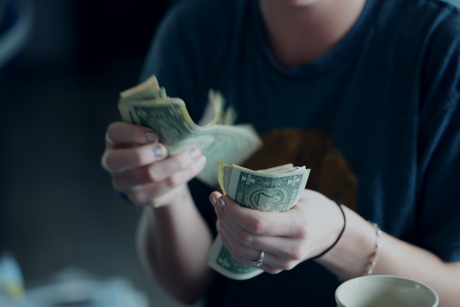 Female personal loan applicant counting one-dollar bills