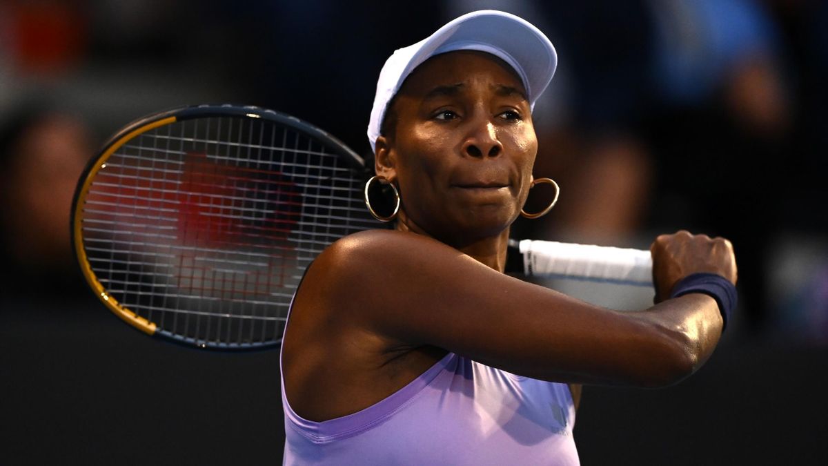 Venus Williams wearing a light purple tennis outfit while holding a tennis racket