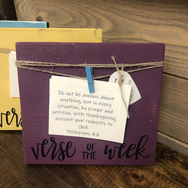 Wooden verse of the week with quote written on paper