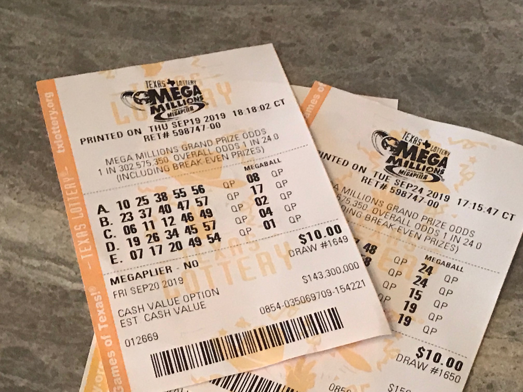 Two Mega Millions tickets lying on table