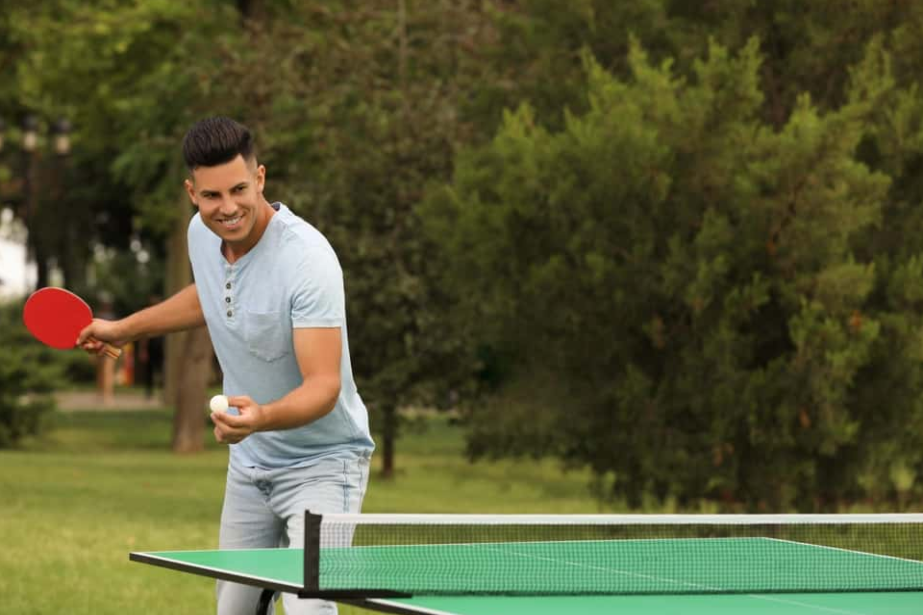 A man outside playing ping-pong