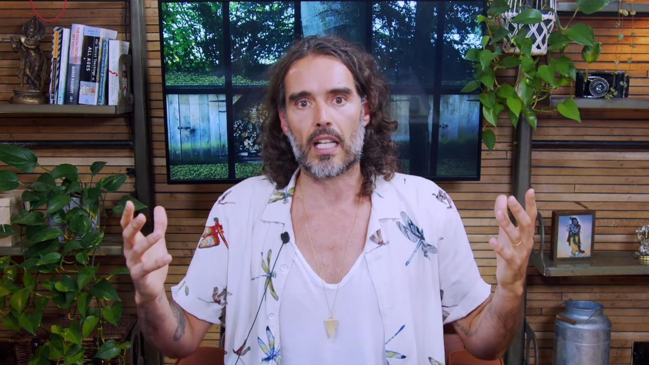 Russell Brand wearing a white polo