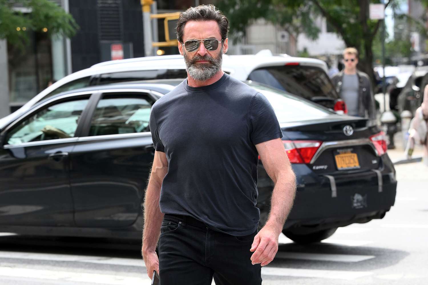 Hugh Jackman wearing a black shirt and sunglasses