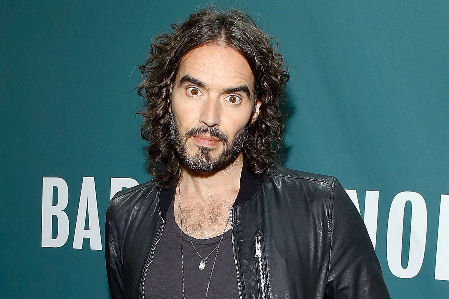 Russell Brand wearing a black jacket