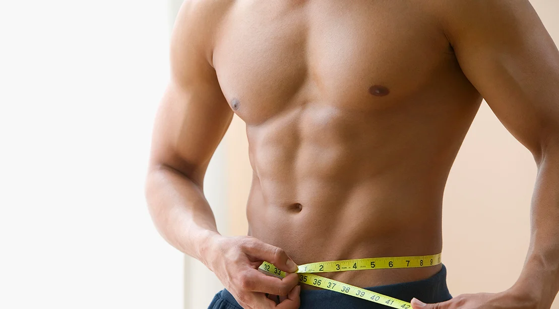 A bodybuilder measuring his waist