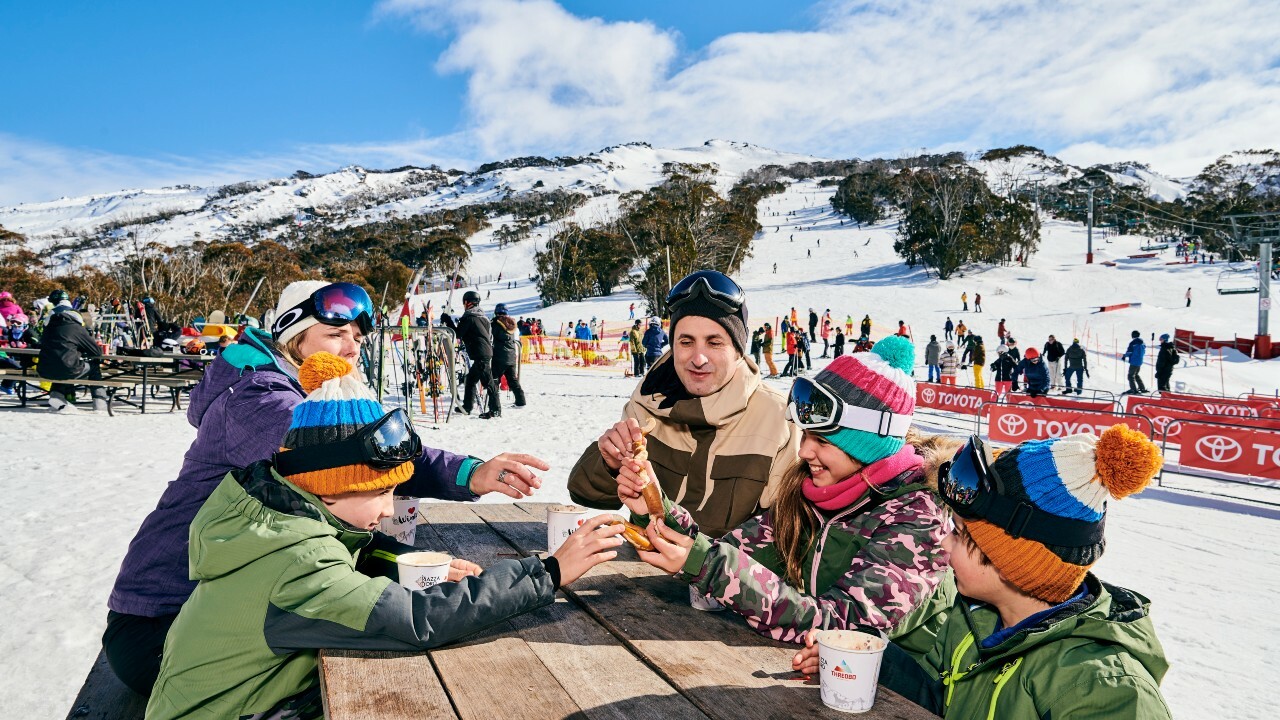 Some people sitting on a table in a restaurant located on the snowy mountain