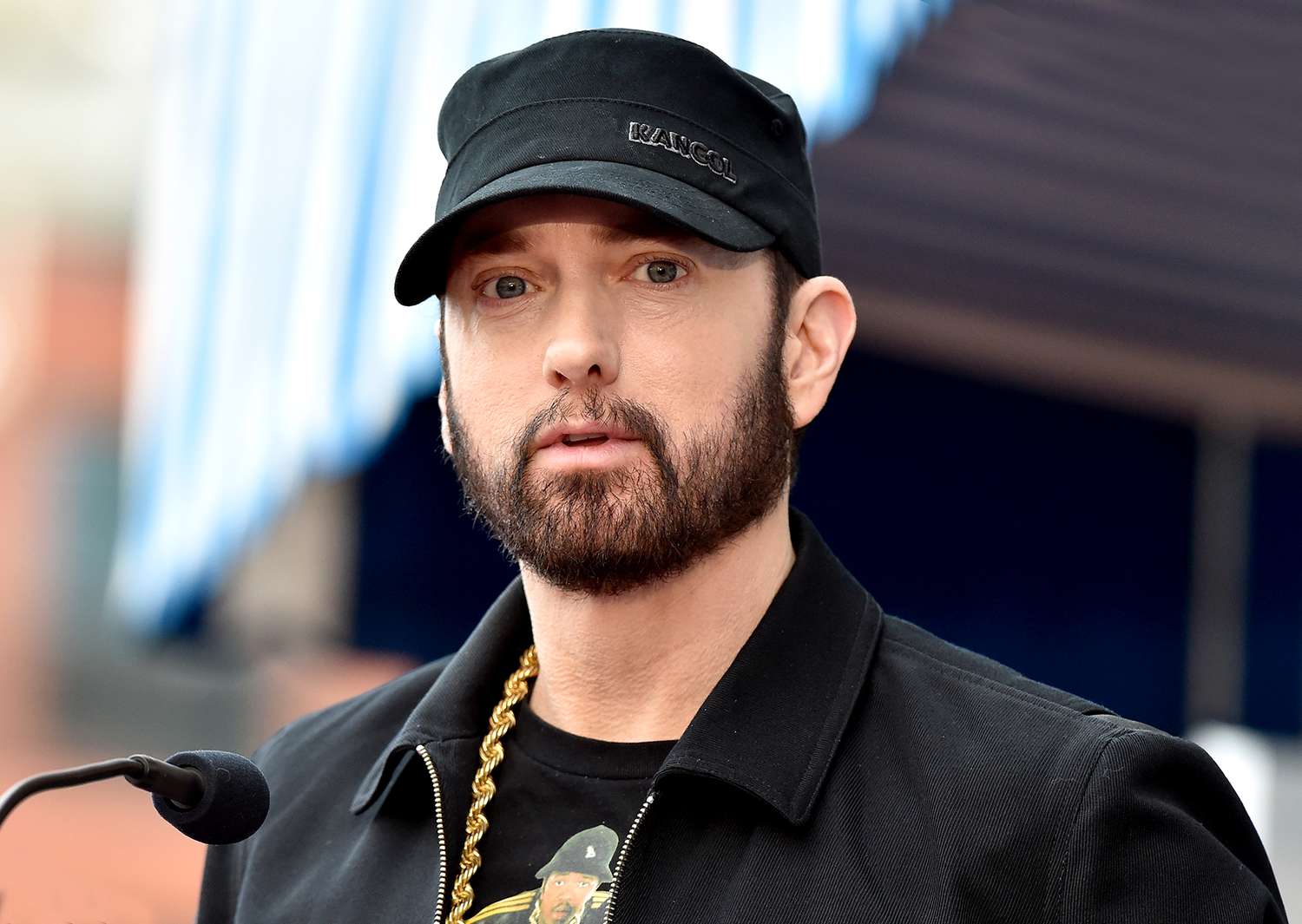 Eminem wearing a black coat and top