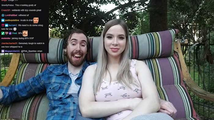 Pink Sparkles and Asmongold sitting on the couch at their backyard