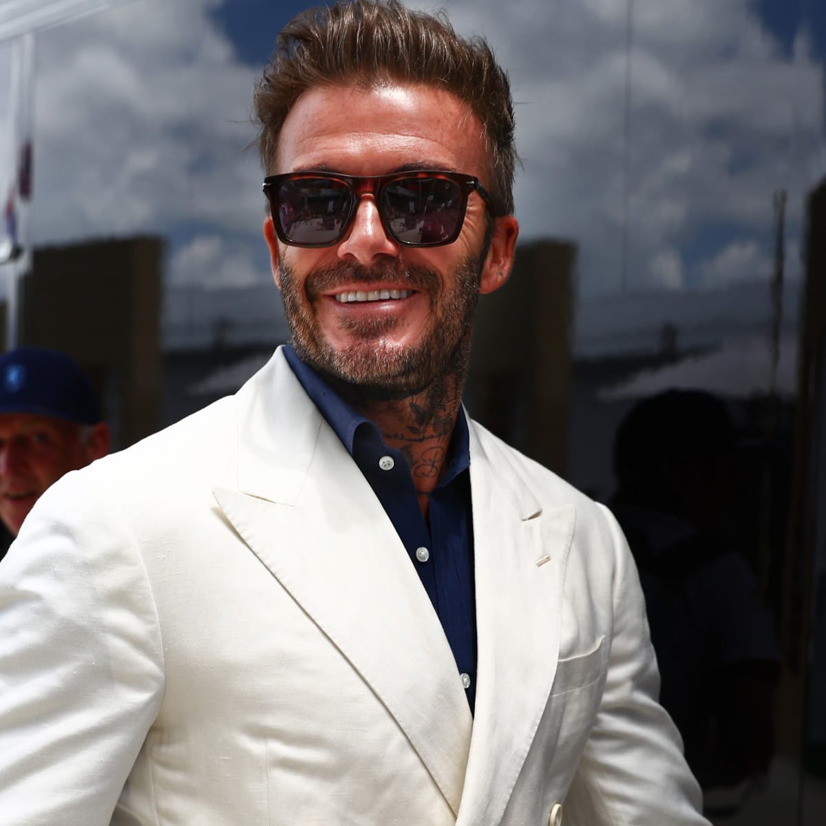 David Beckham wearing a white suit with a sun glass