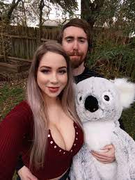 Pink Sparkles holding a koala stuff toy and Asmongold behind her