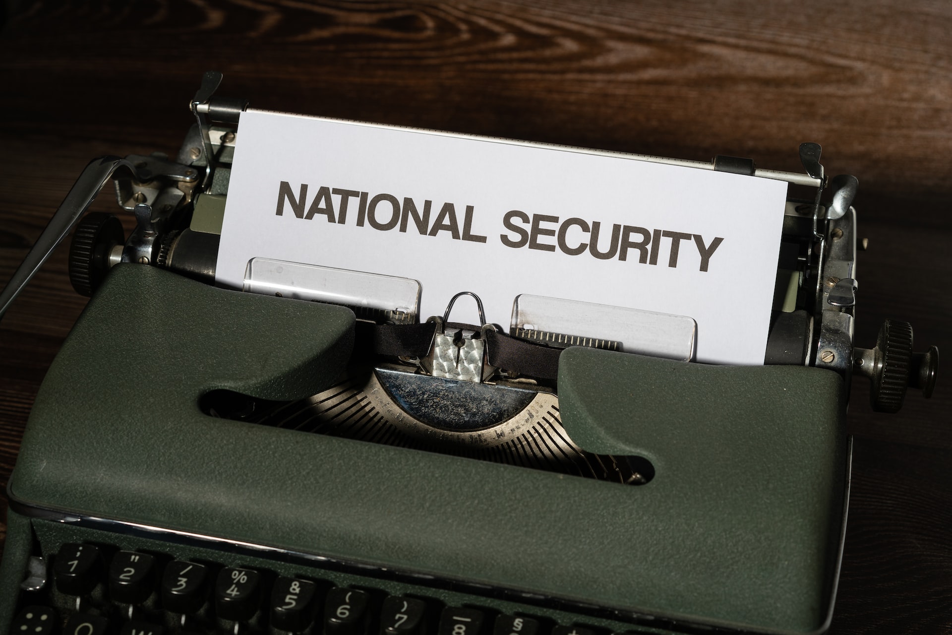 A white bond paper on a typewriter with the words ‘National Security’ in uppercase form