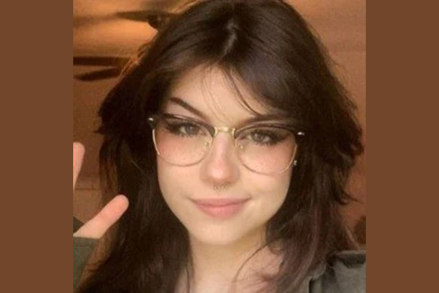 Hannah Owo doing a peace sign and wearing glasses