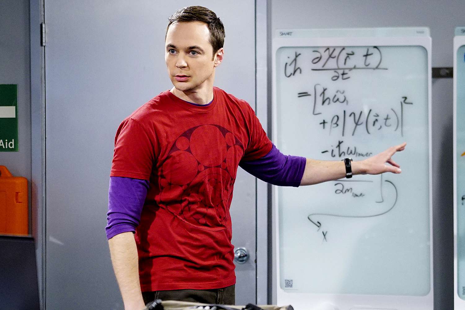 Jim Parsons as Sheldon Cooper wearing a red shirt