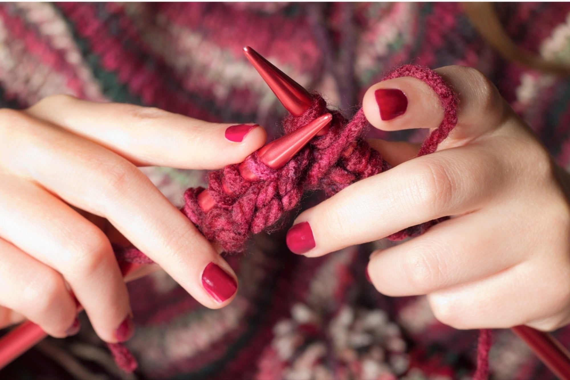 A woman is making something out of wool