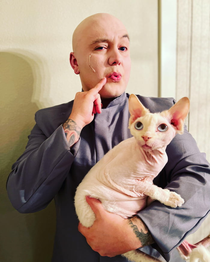 Dr.evil posing while holding bigglesworth in his hands