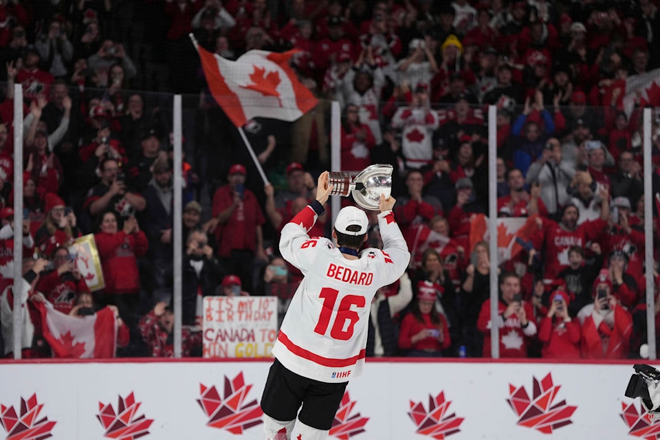 A player named "Bedard" wearing jersey number 16 lifts a trophy in celebration, surrounded by cheering fans draped in Canadian flags and attire.