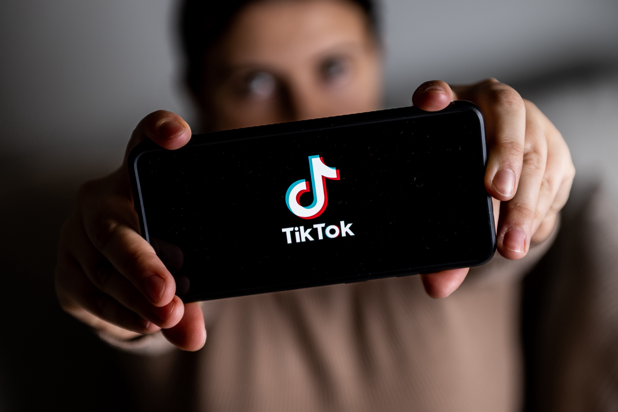 A man holding a phone with TikTok logo