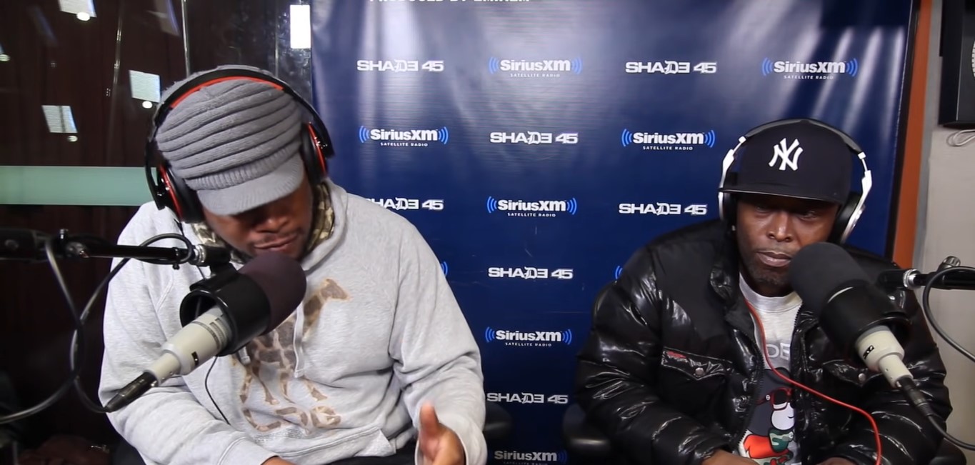 Sway Calloway interviews Black Rob in New York Yankees baseball cap and black puffer jacket at SiriusXM booth