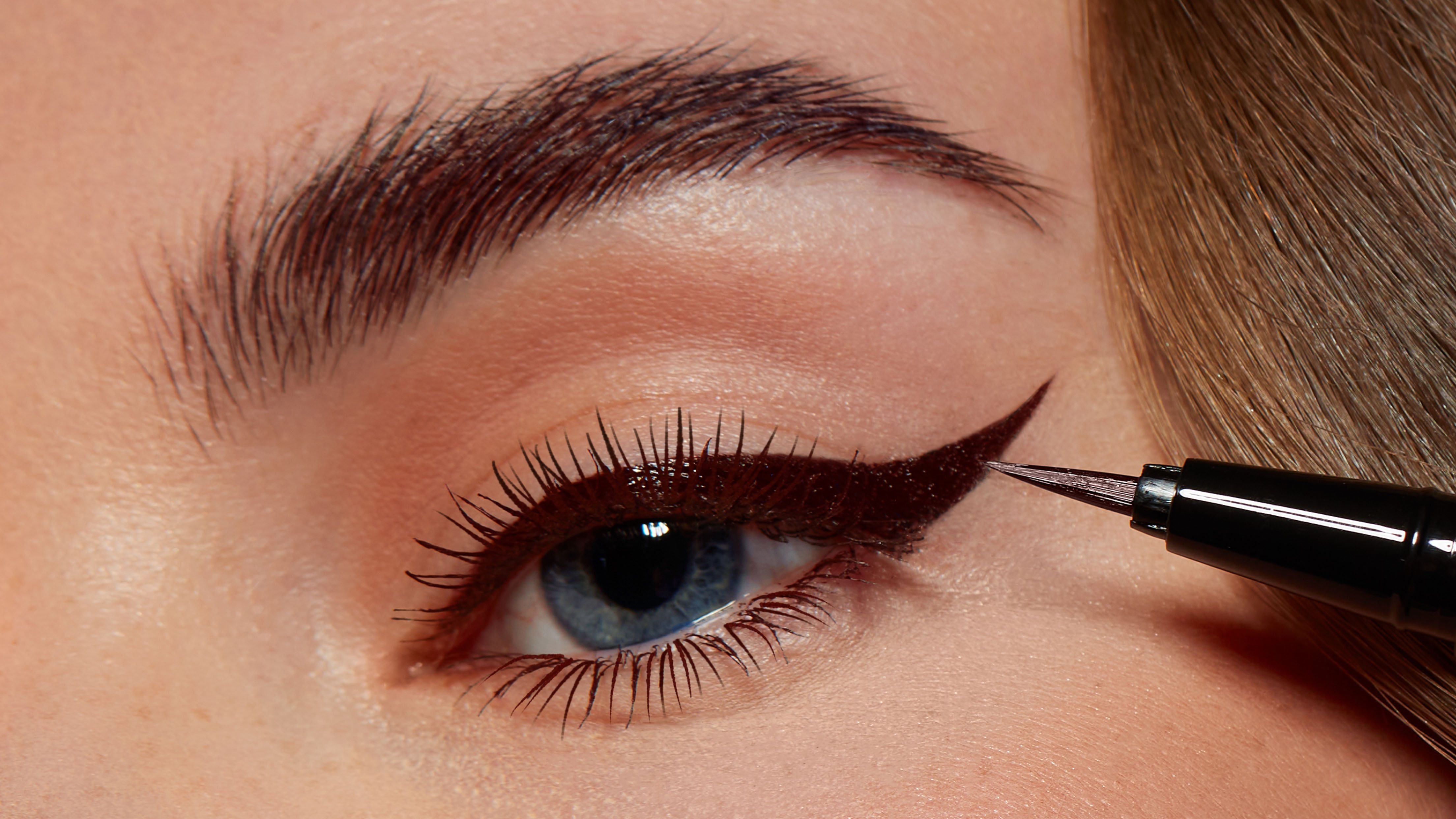 A woman applying eyeliner