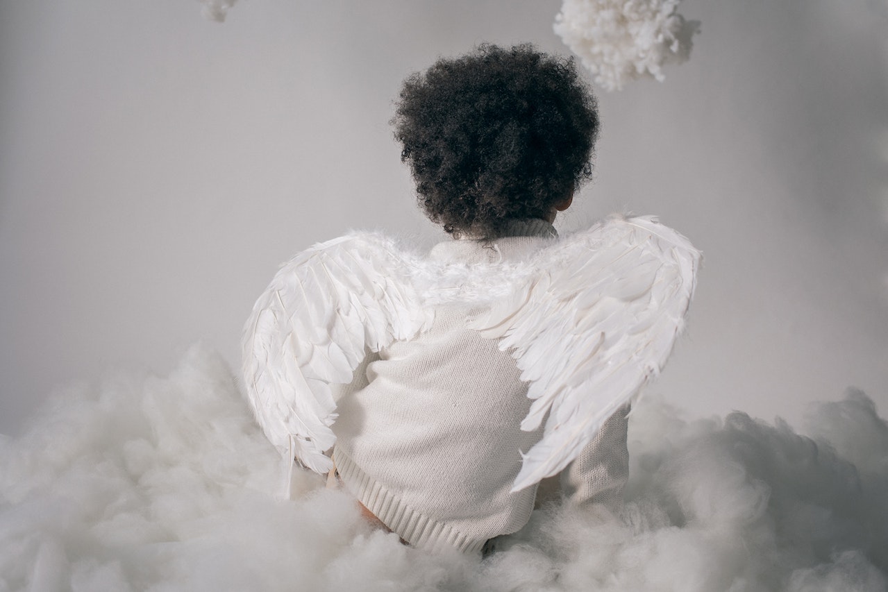 Anonymous Boy in Angel Wings Sitting on Cotton Cloud