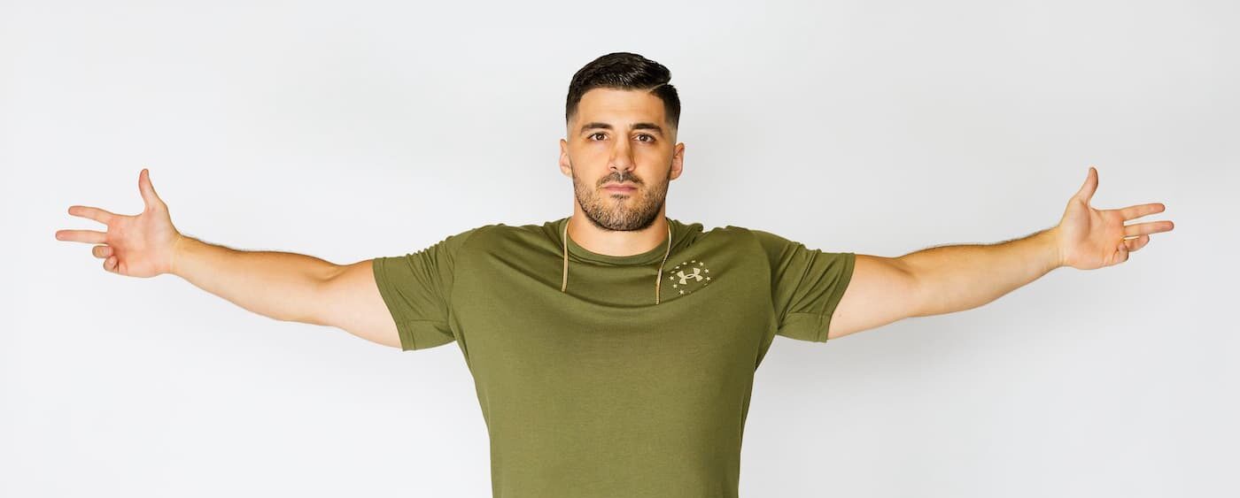 Nickmercs spreading his hands in style wearing green shirt
