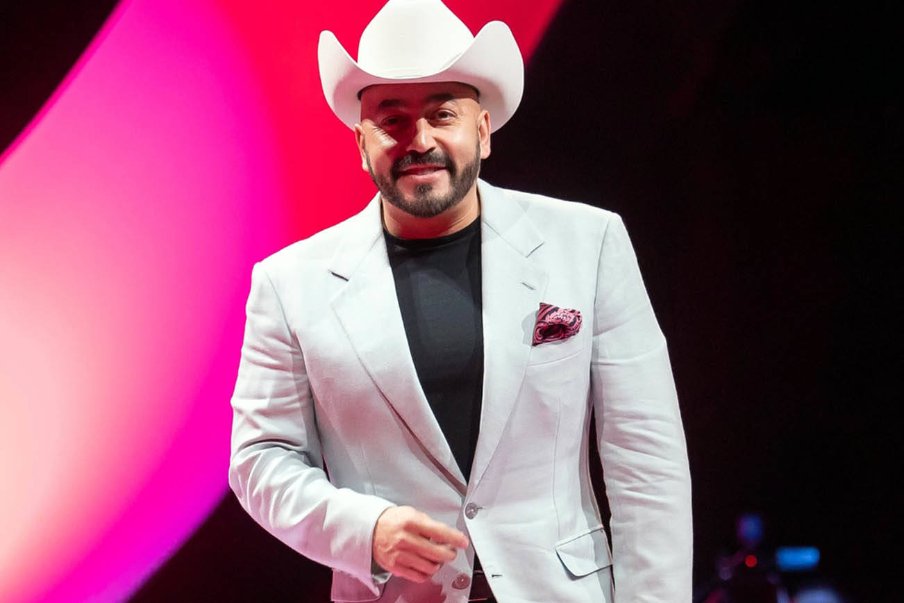 Lupillo Rivera wearing a whote coat and hat