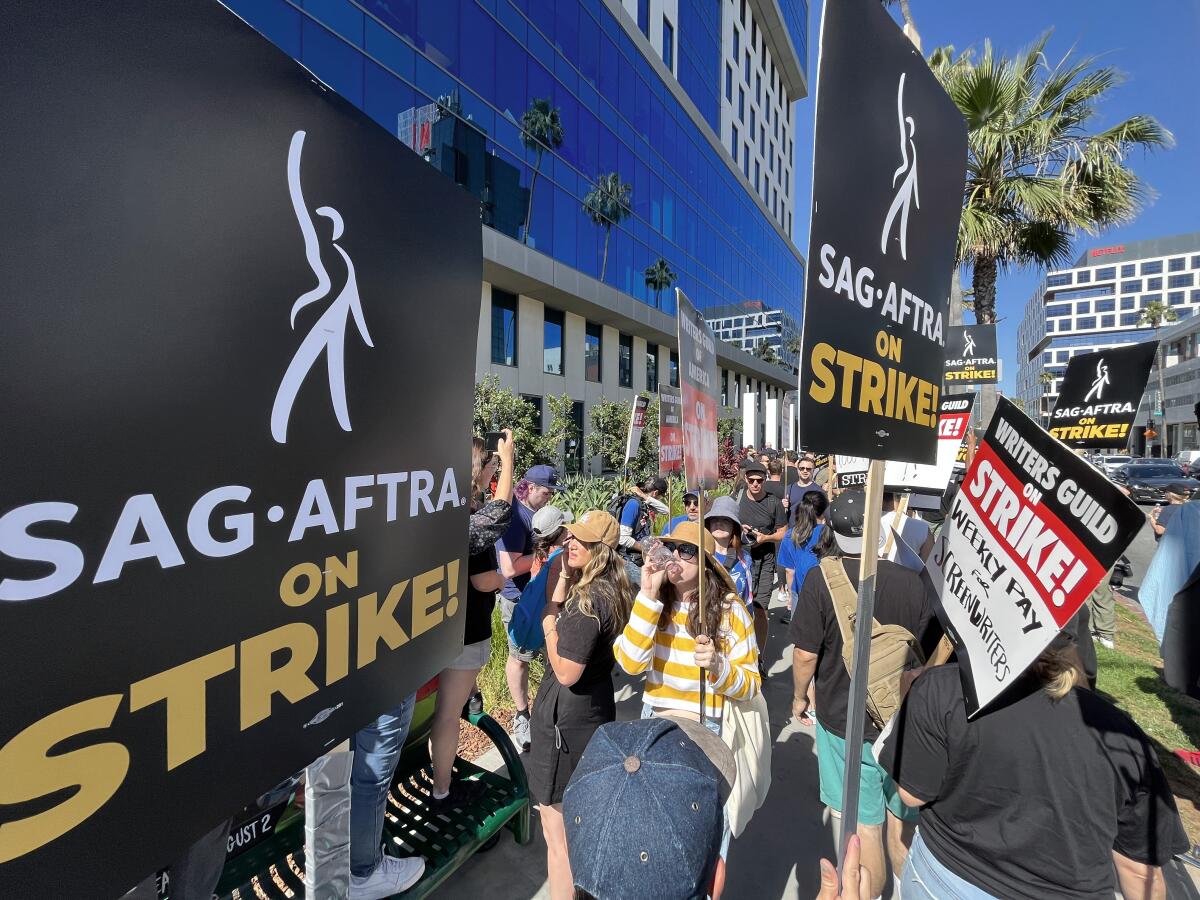 People holding SAG-AFTRA on a strike signages