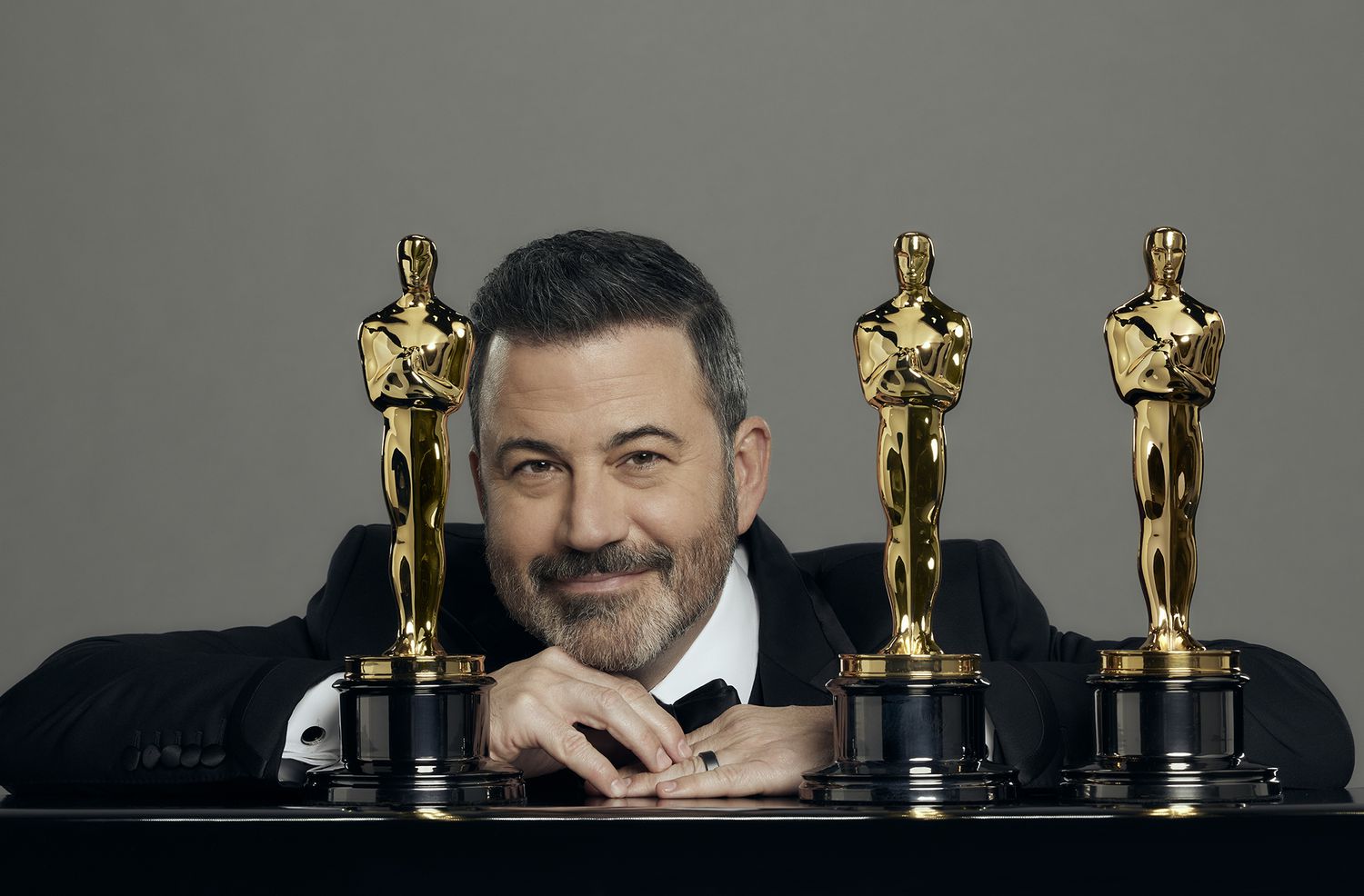 Jimmy Kimmel wearing a black suit with Oscars trophy