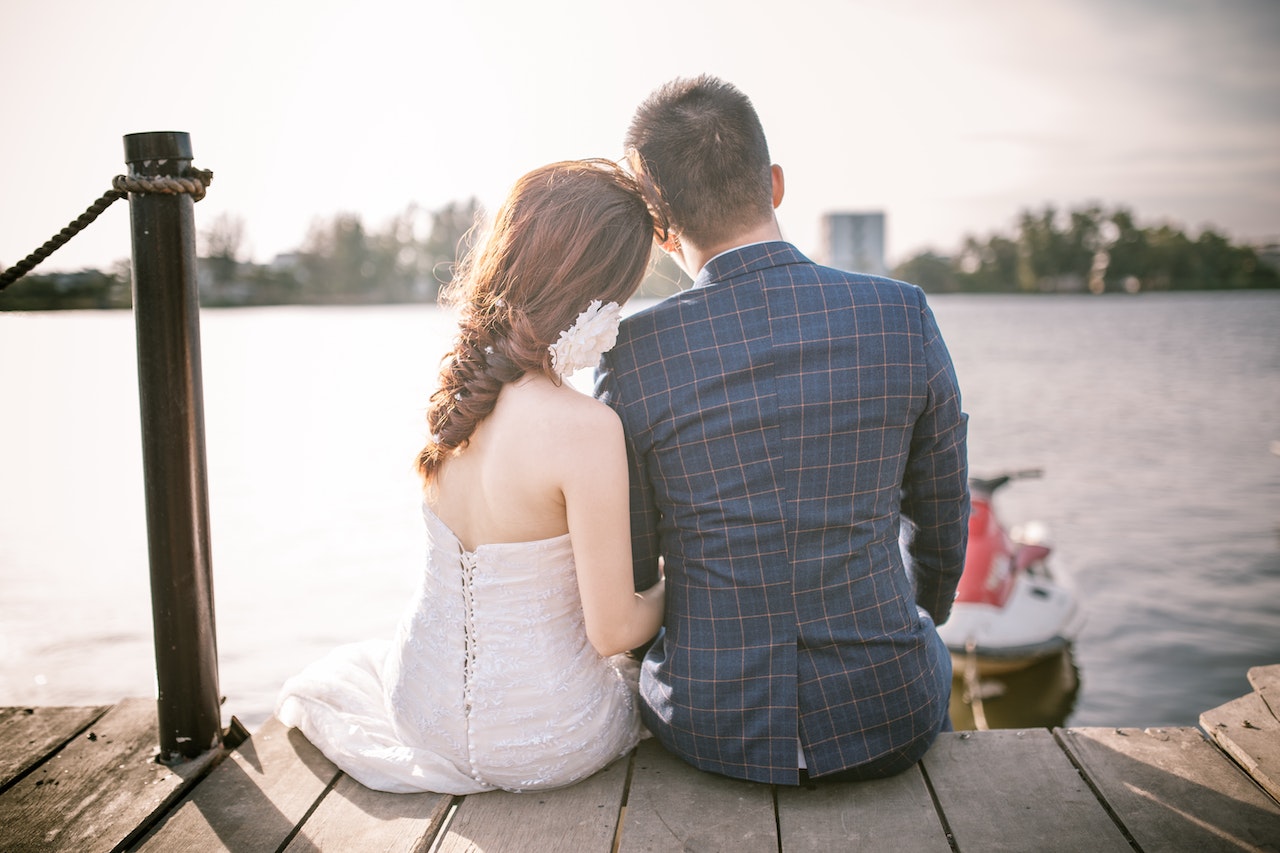 Bride and Groom Sitting on Dock