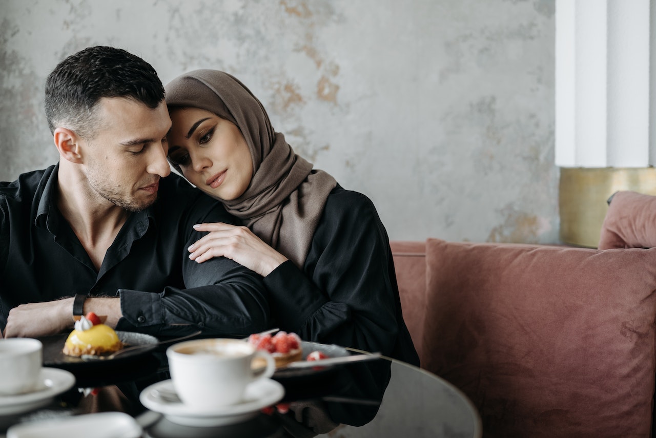 A Man Looking at the Woman Wearing Brown Hijab while in a restaurant