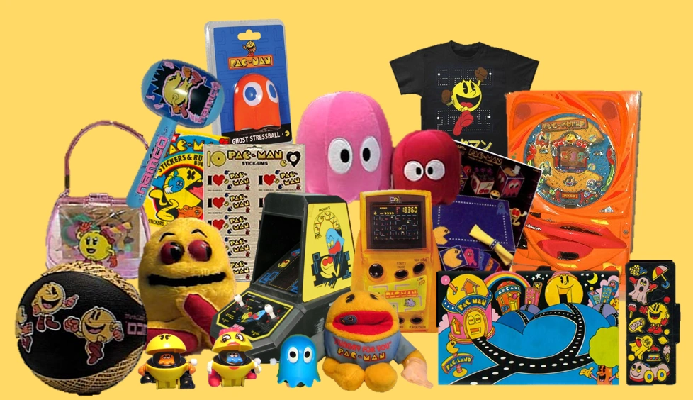 An assortment of PAC-MAN themed merchandise, ranging from toys and plushies to clothing and electronic games.