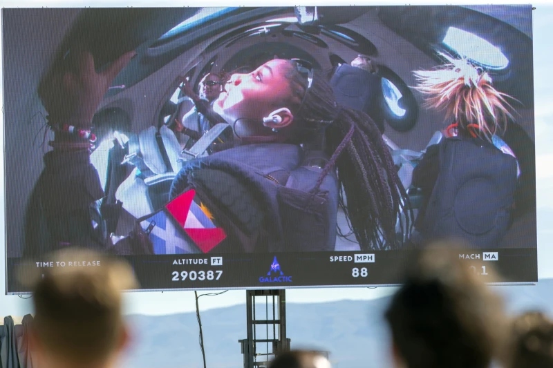 Guests watch a live broadcast from inside Virgin Galactic’s rocket-powered plane Unity 22