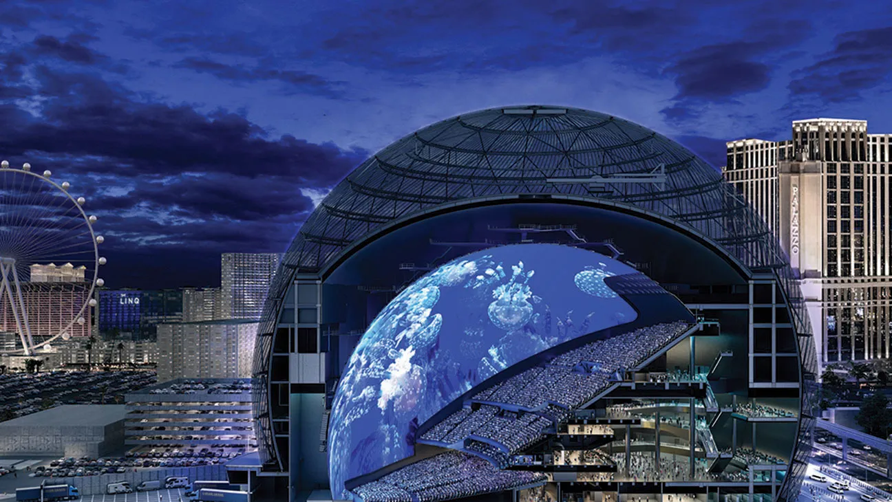 A massive dome-like structure displays a stunning projection of Earth amidst a city skyline during twilight.