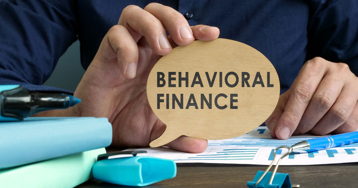 Behavioral finance written on a round sheet being held by a person