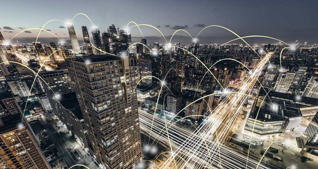 Night view of a bustling city skyline overlaid with illuminated arcs, representing connectivity and the dynamic flow of information in an urban setting.