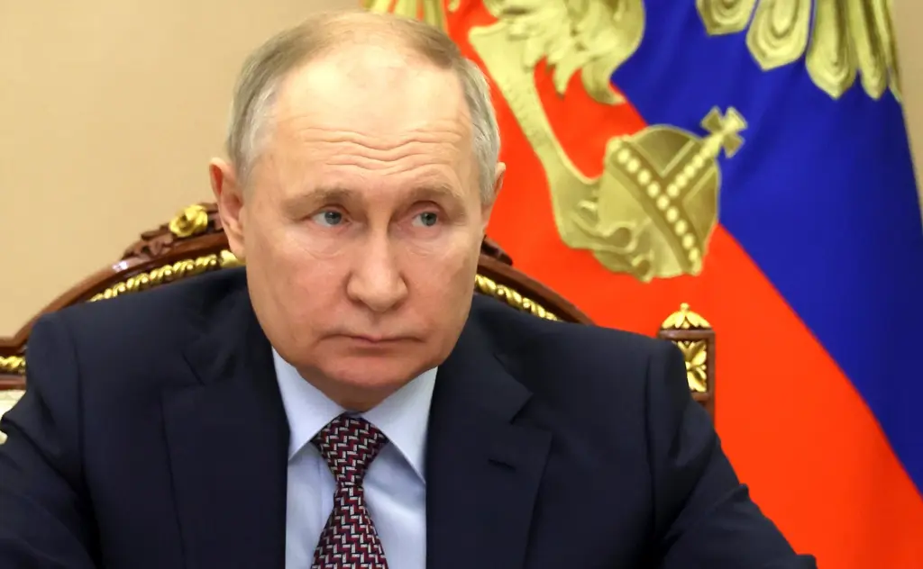 Russian President Vladimir Putin is sitting in chair.