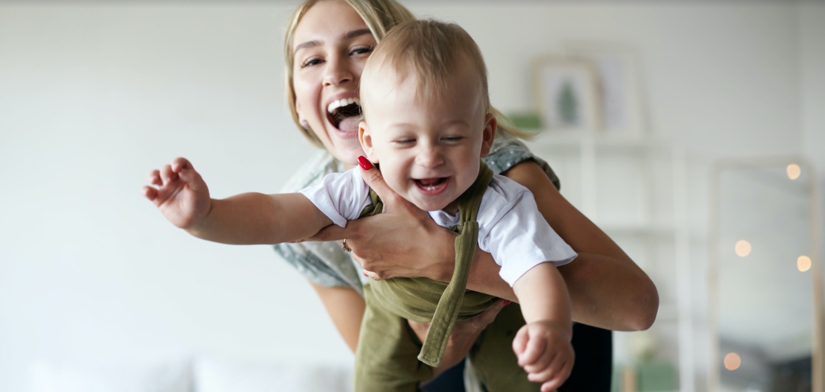 A woman holding a laughing toddler