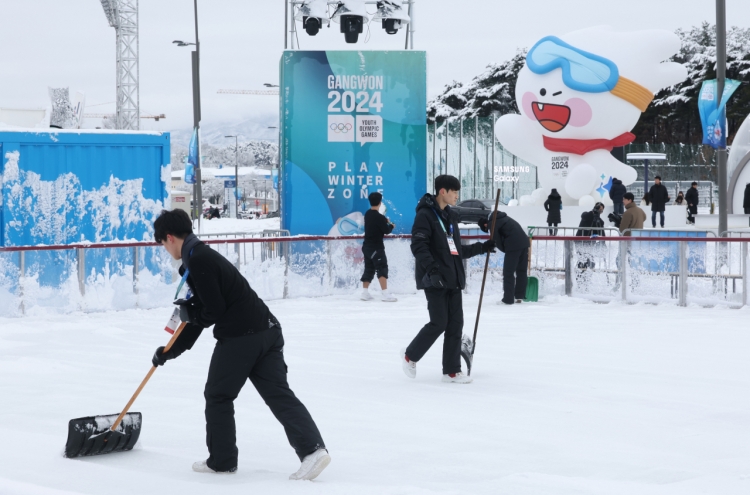 Volunteers clear snow ahead of the single mixed relay biathlon during the Gangwon 2024 Winter Youth Olympic Games at Alpensia Biathlon Centre in Pyeongchang on Sunday.