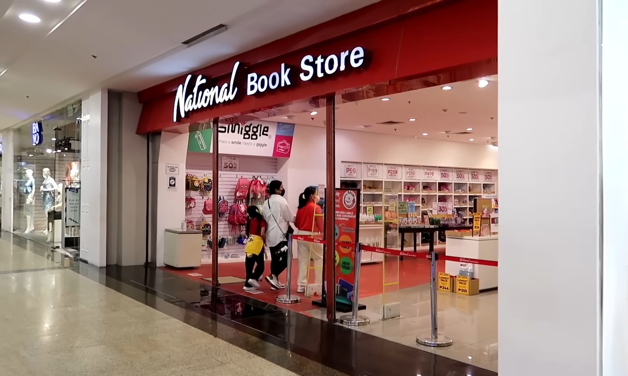 National Book Store beside Bayo inside a mall, with a mother and two daughters in tow at the entrance