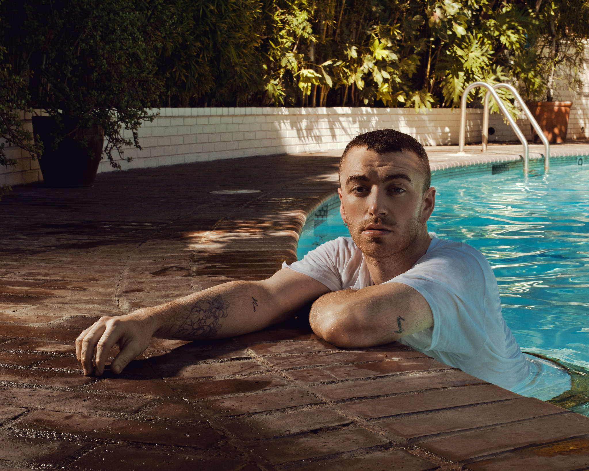 Sam Smith wearing a white shirt on a poool