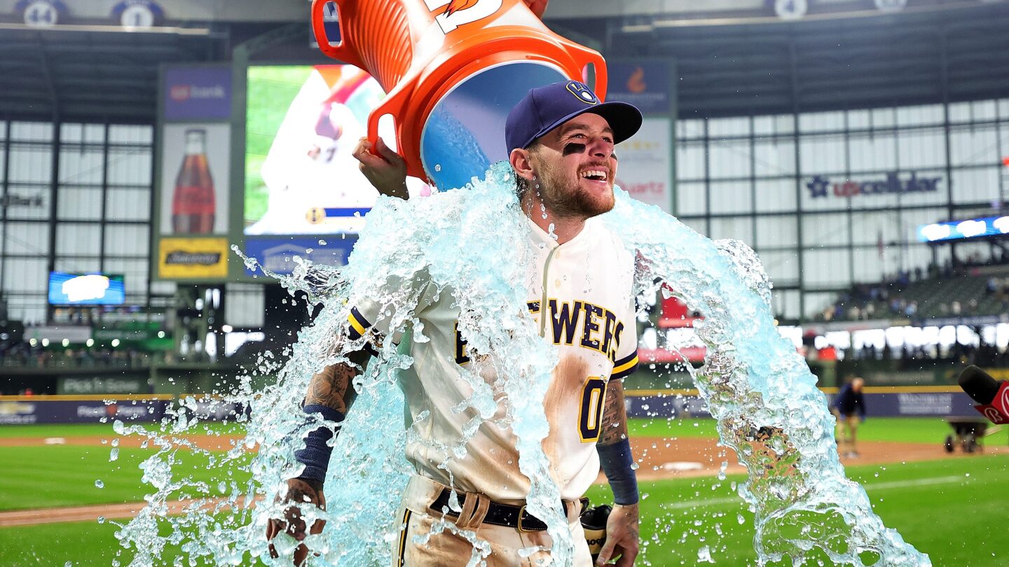 A moment of celebration for a Milwaukee Brewers player who is being drenched with water, likely following a victory or personal achievement on the field.