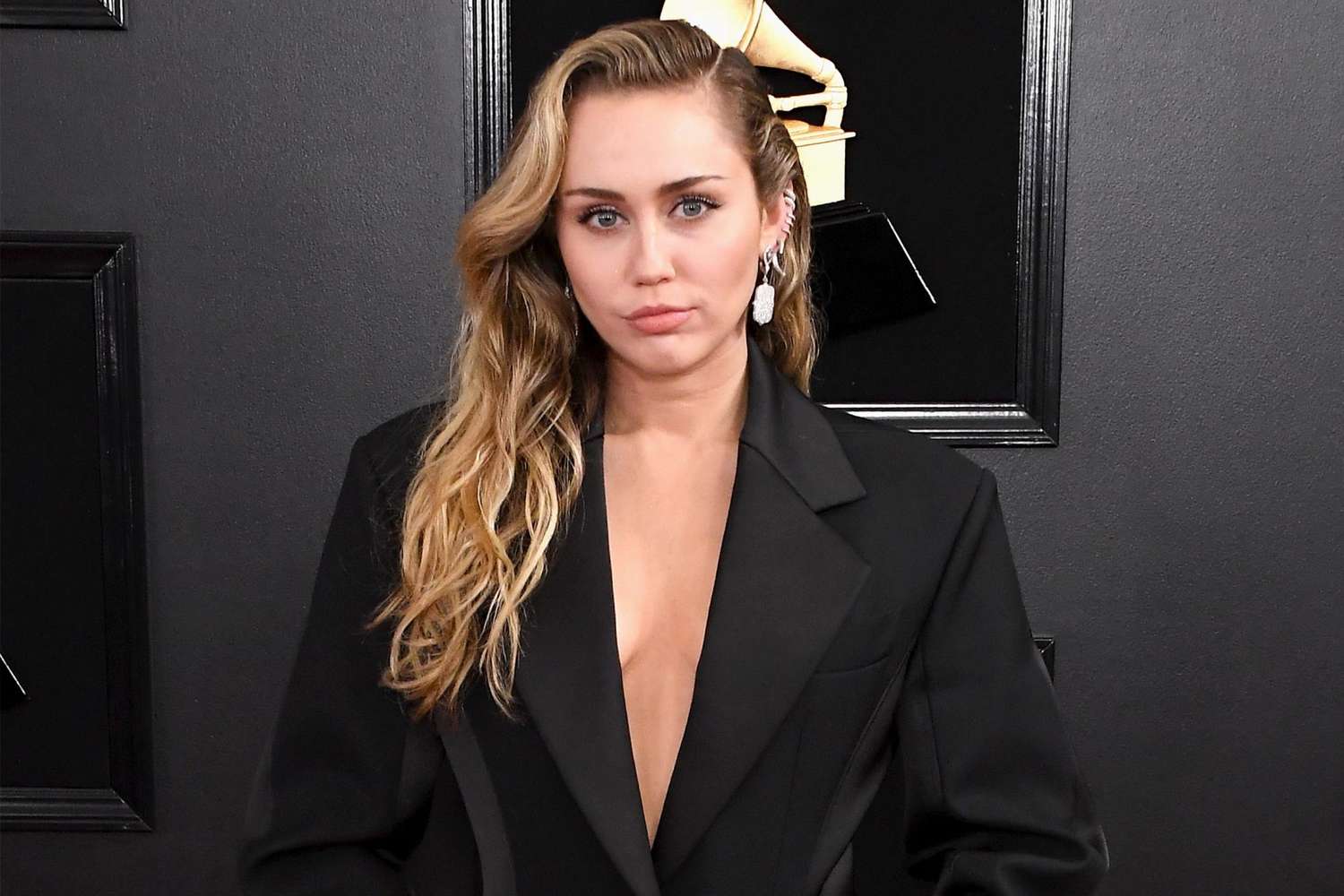 Miley Cyrus wearing a black coat