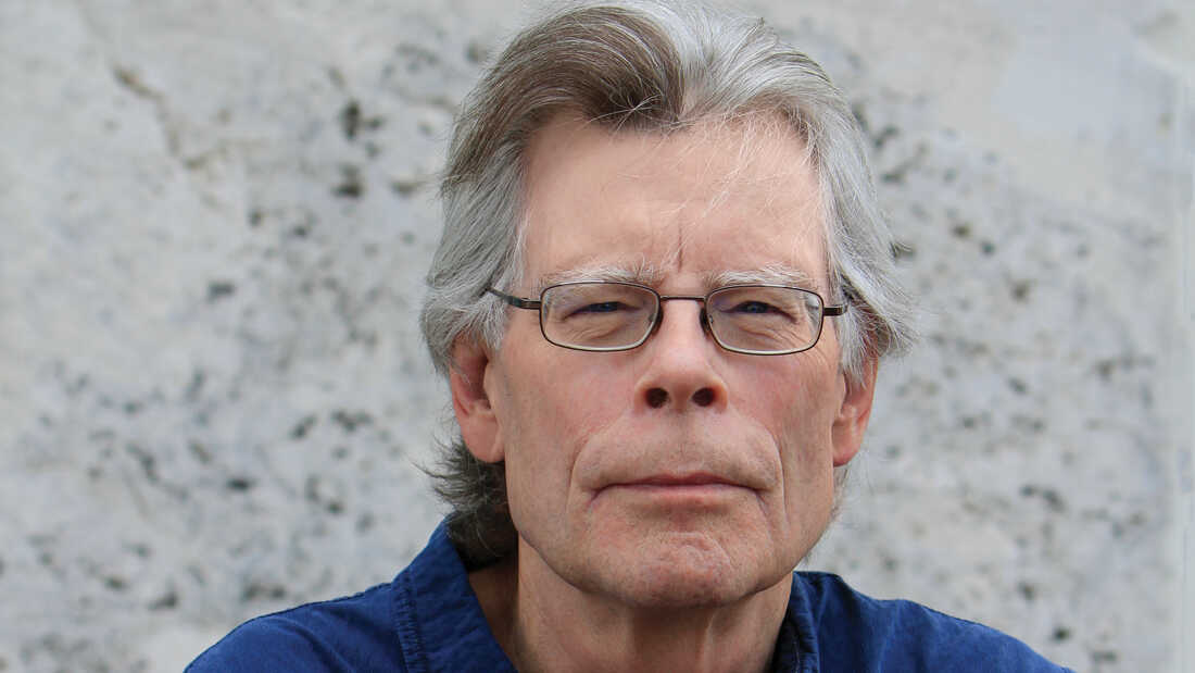 Stephen King wearing a blue polo