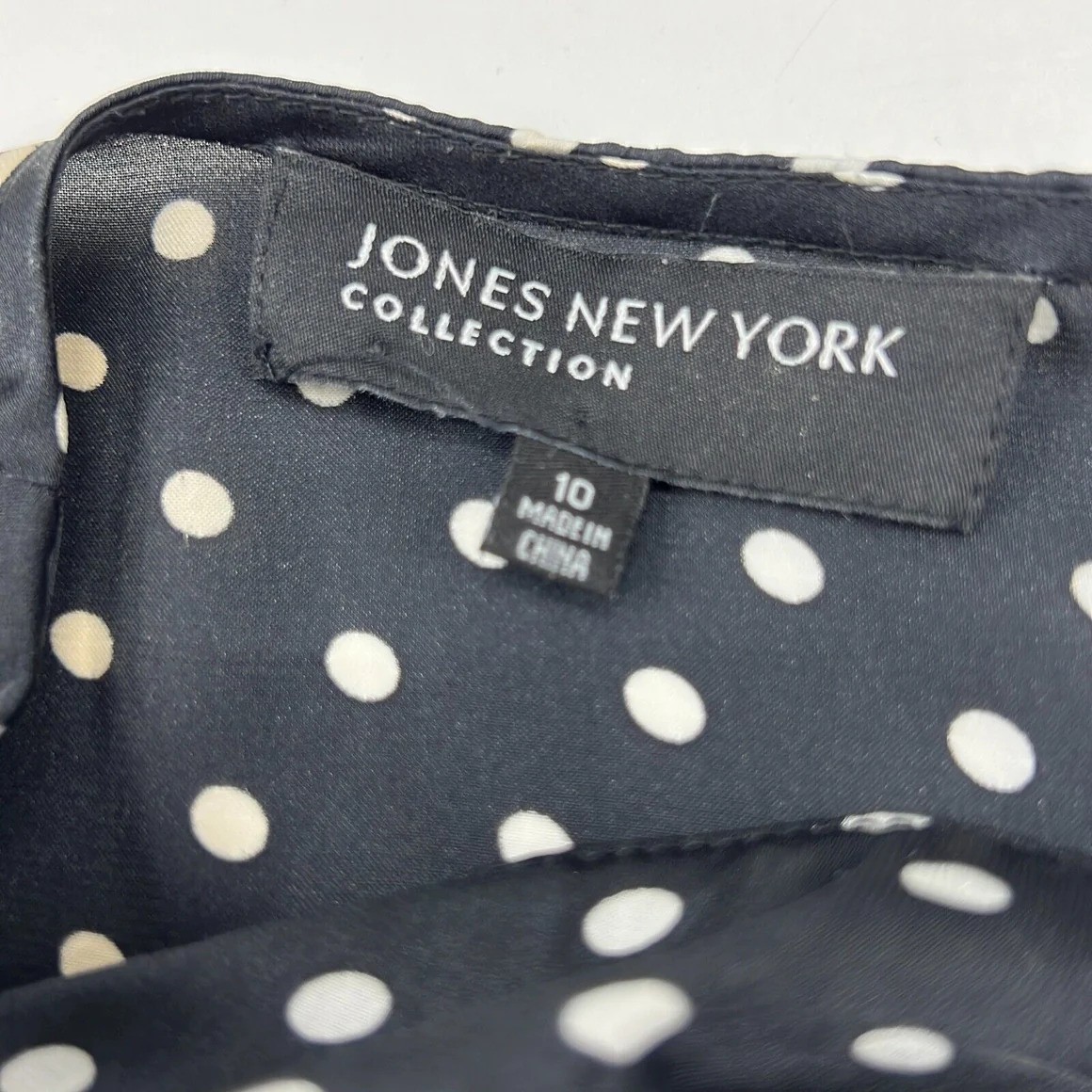 Jones New York label on a black polka dot blouse