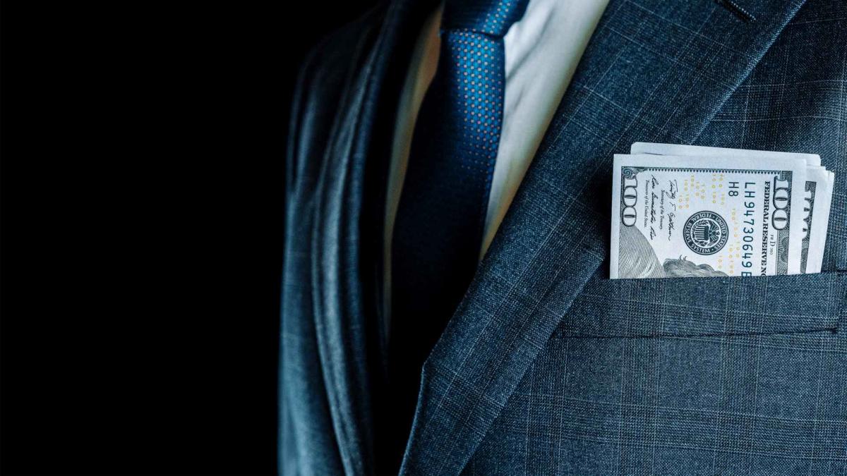 Dollar notes in a man's suit pocket