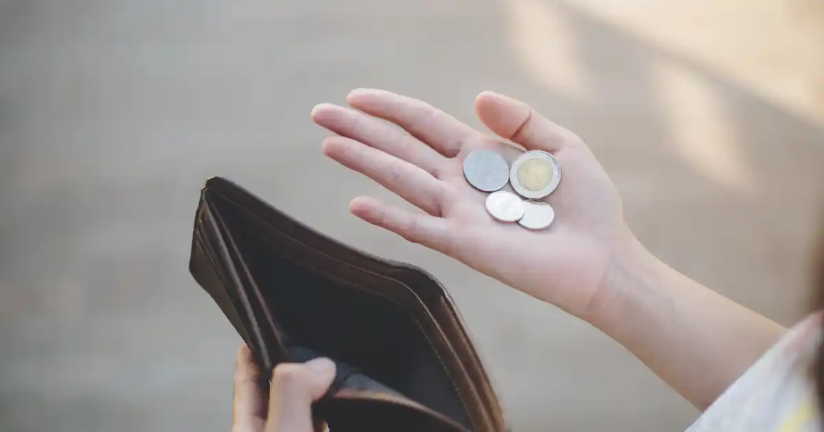 A girl holding coins and wallet in her hands