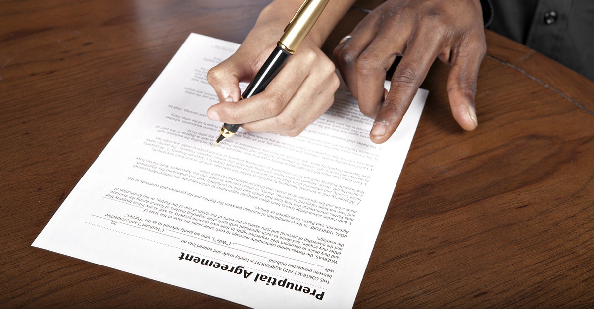 A person signing on a paper