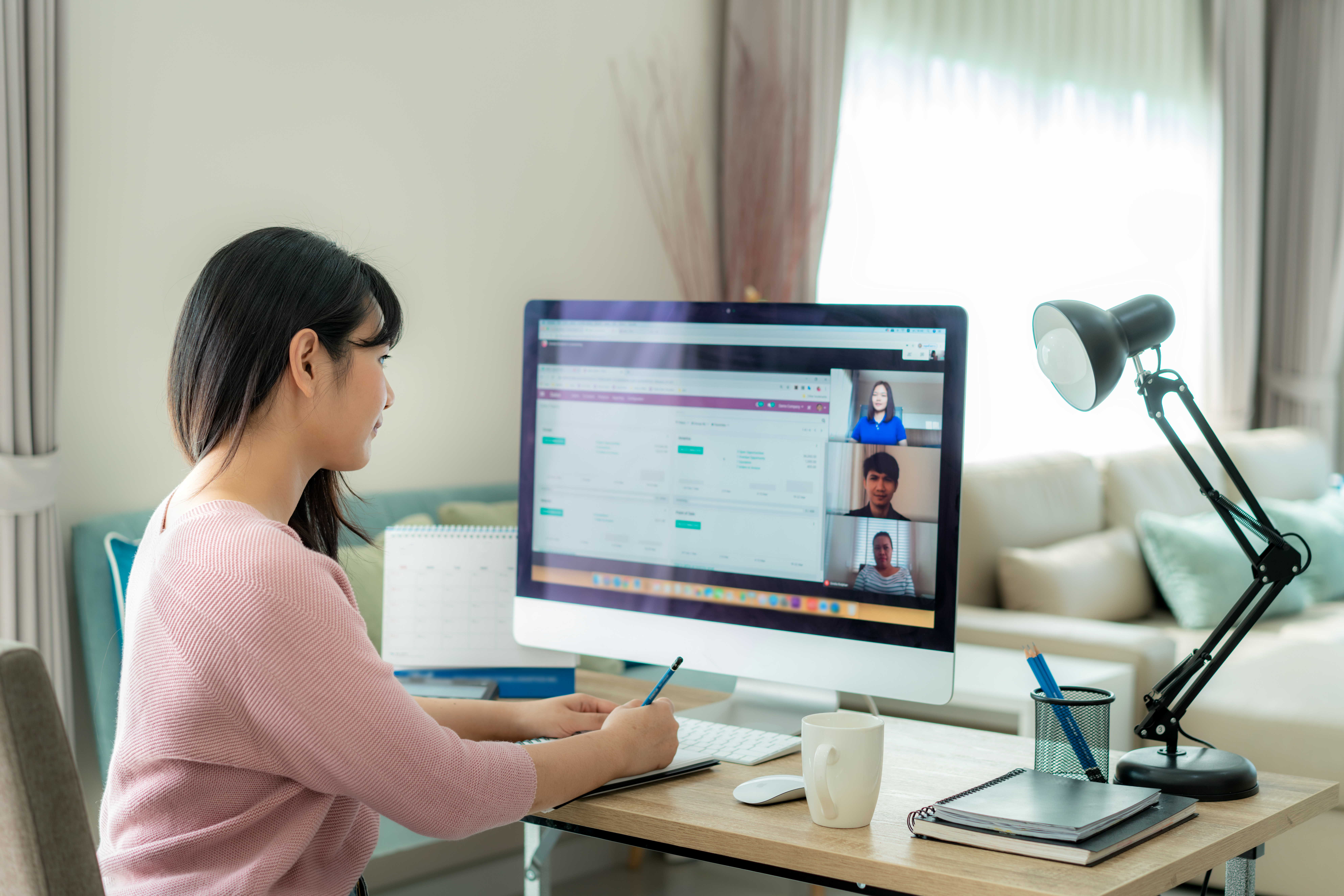 A woman having a work meeting at home via her PC