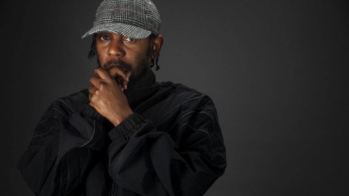 Kendrick Lamar wearing a black jacket and gray cap