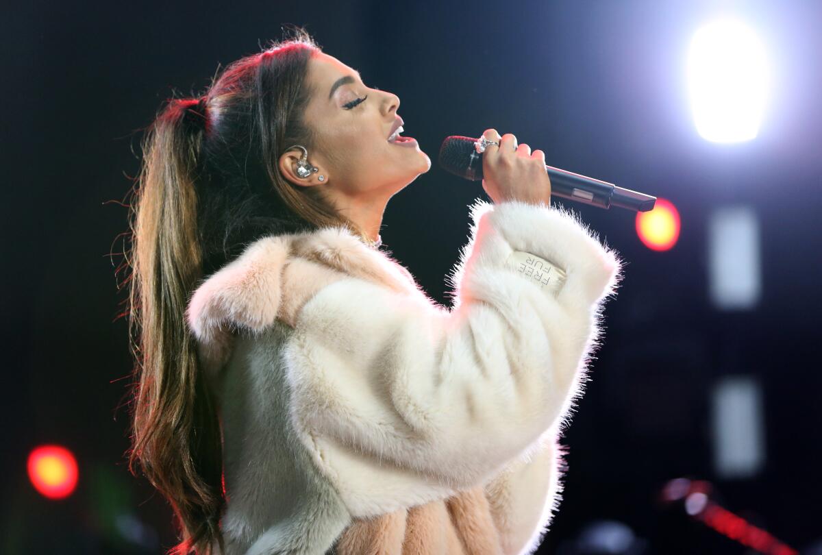 Ariana Grande wearing a fur sweater while singing
